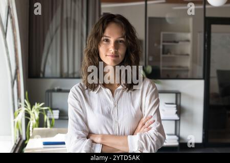 Kopffoto-Porträt einer hübschen jungen Geschäftsfrau, die im Büro posiert Stockfoto