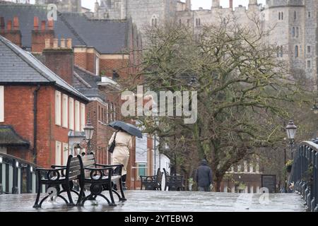 Windsor, Berkshire, Großbritannien. Dezember 2024. Käufer und Touristen hängten heute in Windsor, Berkshire, an ihren Sonnenschirmen, als sie Weihnachtseinkäufe machten. Eine Wetterwarnung für Wind in MET Office Yellow bleibt bis 06,00 Uhr morgen früh, Sonntag, den 8. Dezember, in Kraft. Quelle: Maureen McLean/Alamy Live News Stockfoto