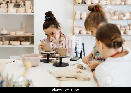 Frauen und Kinder kreieren Keramik in einem hellen Kunststudio Stockfoto