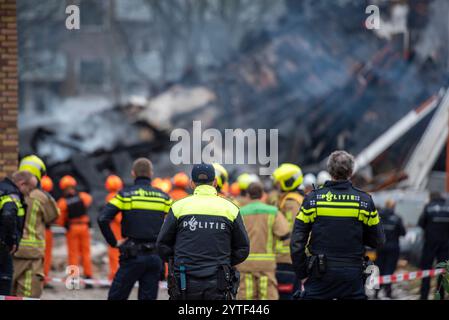 Den Haag, Südholland, Niederlande. Dezember 2024. Die niederländische Polizei kontrolliert und beobachtet, wie niederländische Feuerwehrleute einen Brand löschen, der nach einer Gebäudeexplosion entstanden ist. Am 7. Dezember 2024 ereignete sich um 06:15 Uhr eine Explosion im Wohngebiet von Mariahoeve, den Haag, Niederlande, die erhebliche Schäden verursachte und vier Personen verletzte, die ins Krankenhaus gebracht wurden. Die Zahl der Todesfälle ist unbekannt. Die Behörden untersuchen die Ursache der Explosion, die derzeit noch nicht bekannt ist. (Kreditbild: © James Petermeier/ZUMA Press Wire) NUR REDAKTIONELLE VERWENDUNG! Nicht für com Stockfoto