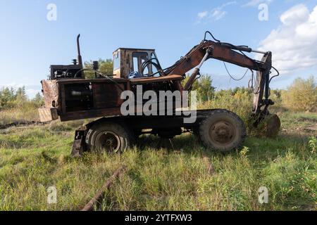 Verlassener Bagger in einer verwachsenen Landschaft. Stockfoto