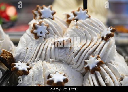 Bad Homburg, Deutschland. Dezember 2024. Mit Zimtsternen dekoriert ist das weihnachtliche Eisgeschmack Cinnamon Stars Ice Cream, das in der Eisdiele 'Gelato Bella Italiano' im Stadtzentrum von Bad Homburg an der Kühltheke zu finden ist. Immer mehr Eisdielen sind auch über den Sommer hinaus geöffnet. Kleine Produzenten und Eisdielen locken Kunden mit kreativen Aromen an. Vermerk: Arne Dedert/dpa/Alamy Live News Stockfoto