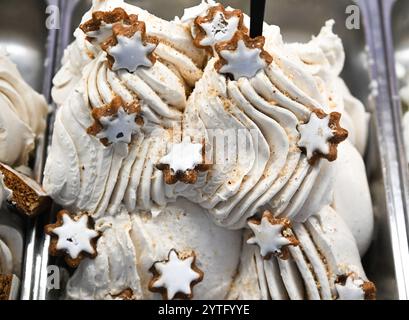 Bad Homburg, Deutschland. Dezember 2024. Mit Zimtsternen dekoriert ist das weihnachtliche Eisgeschmack Cinnamon Stars Ice Cream, das in der Eisdiele 'Gelato Bella Italiano' im Stadtzentrum von Bad Homburg an der Kühltheke zu finden ist. Immer mehr Eisdielen sind auch über den Sommer hinaus geöffnet. Kleine Produzenten und Eisdielen locken Kunden mit kreativen Aromen an. Vermerk: Arne Dedert/dpa/Alamy Live News Stockfoto
