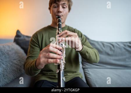 Klarinettenspieler. Klarinettistenhände spielen zu Hause Flöte Holzbläser. Der Typ spielt Oboe Stockfoto