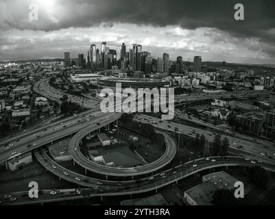 JANUAR 2024, LOS ANGELES, CA. - Luftaufnahme der Skyline VON LA bei Sonnenuntergang mit der Kreuzung von Harbor Freeway 110 und Interstate Highway 10 mit Verkehr Stockfoto