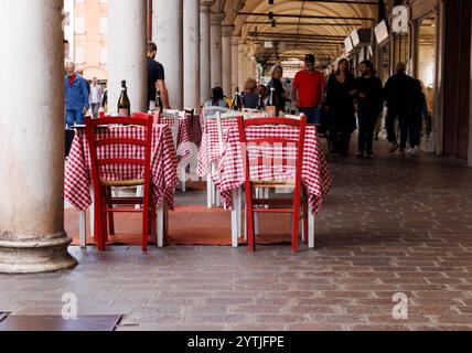 Mantova, Italien - 15. September 2024: Leere Tische und Stühle vor einem Restaurant unter den berühmten Porticos der Stadt, mit Tischen mit dem Klassiker Stockfoto