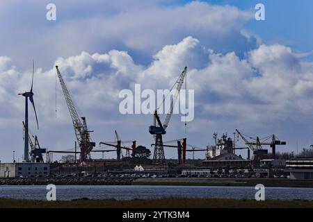 Viana do Castelo, Portugal - 2. März 2024: Ein landschaftlich reizvoller Industriehafen in Viana do Castelo, Portugal, mit Kränen, einer Windturbine und einem angedockten Schiff Stockfoto