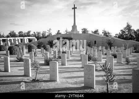 Der Kriegsfriedhof El Alamein in Ägypten ehrt Soldaten des Zweiten Weltkriegs mit Reihen von Militärgräbern, dem Opferkreuz und einer ruhigen Wüstenkulisse. Stockfoto