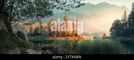 Malerische Panoramalandschaft an einem Bergsee in Deutschland, eingerahmt von Baumästen, mit einem wunderschönen Sonnenstrahl, der ein kleines i erleuchtet Stockfoto