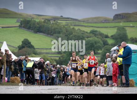 Läufer des Kilnsey Crag Fell Rennens, das bei der Kilnsey Show im Yorkshire Dales National Park, Großbritannien, ausgetragen wurde. Stockfoto
