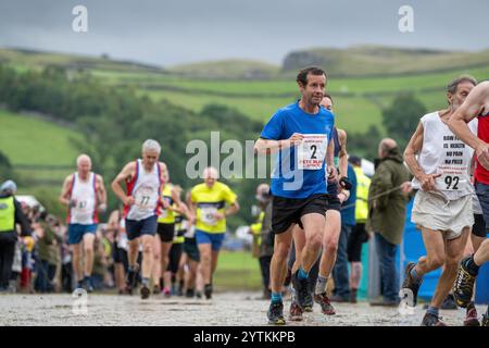 Läufer des Kilnsey Crag Fell Rennens, das bei der Kilnsey Show im Yorkshire Dales National Park, Großbritannien, ausgetragen wurde. Stockfoto
