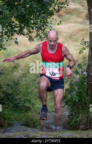 Läufer des Kilnsey Crag Fell Rennens, das bei der Kilnsey Show im Yorkshire Dales National Park, Großbritannien, ausgetragen wurde. Stockfoto