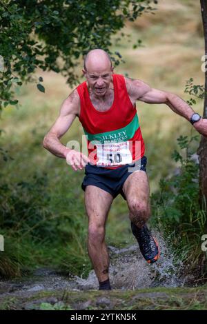 Läufer des Kilnsey Crag Fell Rennens, das bei der Kilnsey Show im Yorkshire Dales National Park, Großbritannien, ausgetragen wurde. Stockfoto