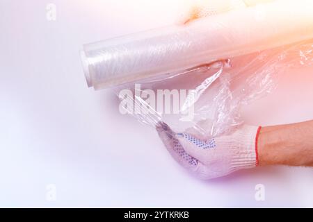 Stretchfolie und Kartonverpackung auf weißem Hintergrund Draufsicht. Verpackung von Waren. Ein Messer zum Schneiden von Karton. Stockfoto