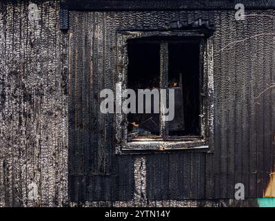 Verkohlte Holzwand des verbrannten Gebäudes, Brandnachwirkungen. Stockfoto