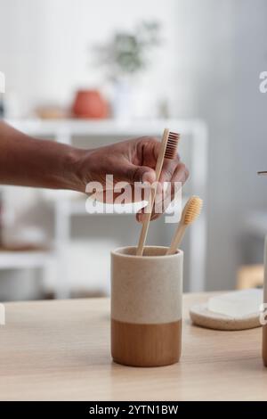 Zahnbrste, Bambus und schwarzer Mann im Studio mit Zahnpasta,  Wasserspritzer und Portrt fr die Verkaufsfrderung von Zahn-, Mund- und  Holzprodukten. - Das ist ein Vorbild Stockfotografie - Alamy