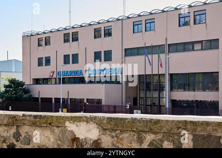 Savona. Italia - 07. Dezember 2024: Vorderansicht des Bürogebäudes der italienischen Küstenwache in Savona mit offiziellen Schildern und Nationalflaggen, c Stockfoto