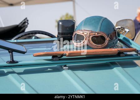 Blaugrüner Oldtimer-Helm und Brille an einem alten Auto Stockfoto