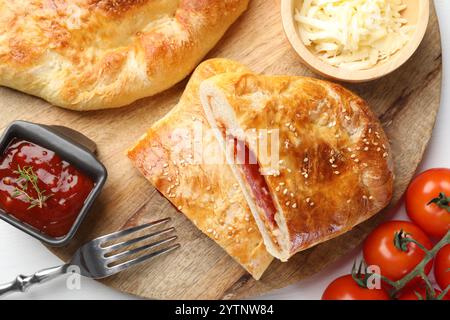 Frische Calzone-Pizza, serviert auf weißem Holztisch, Blick von oben Stockfoto