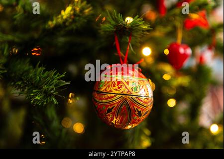 Nahaufnahme eines goldenen und roten Schäfers, der an einem Weihnachtsbaum hängt Stockfoto
