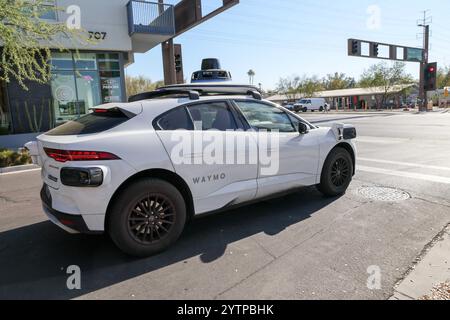 Tempe, USA. Dezember 2024. Ein Waymo selbstfahrendes Jaguar I-PACE Elektrofahrzeug wird am 6. Dezember 2024 an einer roten Ampel in Tempe, Arizona, angehalten. Waymo arbeitet mit Usern von Uber Eats in Phoenix, Chandler, Mesa und Tempe zusammen und arbeitet mit ausgewählten Händlern in diesen Städten zusammen. Darüber hinaus hat Waymo sein Servicegebiet auf 90 Quadratkilometer Metro Phoenix für Waymo One-Fahrer erweitert und ist damit das größte autonome Ride-Hagel-Gebiet in den Vereinigten Staaten. (Foto: Alexandra Buxbaum/SIPA USA) Credit: SIPA USA/Alamy Live News Stockfoto