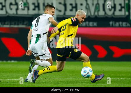 Mönchengladbach, Deutschland. Dezember 2024. Julian Weigl (L) von Borussia Mönchengladbach streitet mit Julian Ryerson von Borussia Dortmund im ersten Bundesliga-Spiel zwischen Borussia Mönchengladbach und Borussia Dortmund am 7. Dezember 2024 in Mönchengladbach. Quelle: Joachim Bywaletz/Xinhua/Alamy Live News Stockfoto