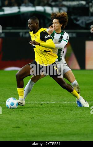 Mönchengladbach, Deutschland. Dezember 2024. Itakura Kou (R) von Borussia Mönchengladbach streitet mit Serhou Guirassy von Borussia Dortmund während des ersten Ligaspiels zwischen Borussia Mönchengladbach und Borussia Dortmund am 7. Dezember 2024 in Mönchengladbach. Quelle: Joachim Bywaletz/Xinhua/Alamy Live News Stockfoto