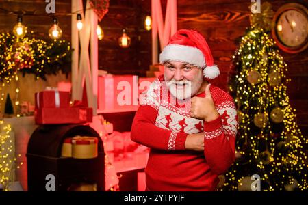 Erfolgreiche Party. weihnachtsgeschenke und -Geschenke. Winterurlaub. Partyzeit. Frohes neues Jahr 2020. Warme Kleidung in der kalten Jahreszeit. Fröhlicher weihnachtsmann rot Stockfoto