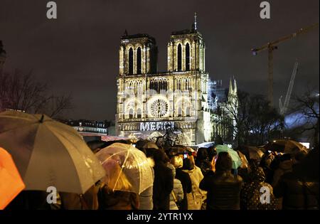 Paris, Frankreich. Dezember 2024. Die Menschen versammeln sich vor der restaurierten Kathedrale Notre-Dame de Paris im Regen in Paris, Frankreich, 7. Dezember 2024. Fünf Jahre nachdem sie von einem Feuer verwüstet worden war, wurde die restaurierte Kathedrale Notre-Dame de Paris am Samstag offiziell mit einer großen Einweihungszeremonie wieder eröffnet, an der sowohl Führer der Welt, Gläubige als auch Nichtgläubige teilnahmen. Quelle: Gao Jing/Xinhua/Alamy Live News Stockfoto