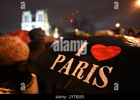 Paris, Frankreich. Dezember 2024. Die Menschen versammeln sich vor der restaurierten Kathedrale Notre-Dame de Paris im Regen in Paris, Frankreich, 7. Dezember 2024. Fünf Jahre nachdem sie von einem Feuer verwüstet worden war, wurde die restaurierte Kathedrale Notre-Dame de Paris am Samstag offiziell mit einer großen Einweihungszeremonie wieder eröffnet, an der sowohl Führer der Welt, Gläubige als auch Nichtgläubige teilnahmen. Quelle: Julien Mattia/Xinhua/Alamy Live News Stockfoto