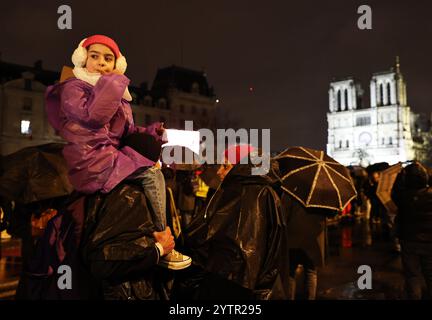 Paris, Frankreich. Dezember 2024. Die Menschen versammeln sich vor der restaurierten Kathedrale Notre-Dame de Paris im Regen in Paris, Frankreich, 7. Dezember 2024. Fünf Jahre nachdem sie von einem Feuer verwüstet worden war, wurde die restaurierte Kathedrale Notre-Dame de Paris am Samstag offiziell mit einer großen Einweihungszeremonie wieder eröffnet, an der sowohl Führer der Welt, Gläubige als auch Nichtgläubige teilnahmen. Quelle: Gao Jing/Xinhua/Alamy Live News Stockfoto