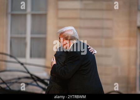 Paris, Frankreich. Dezember 2024. Der neu gewählte US-Präsident Donald Trump umarmt den frechen Präsidenten Emmanuel Macron im Elysée Palace. Der französische Präsident Emmanuel Macron empfing den neu gewählten US-Präsidenten Donald Trump zu einem Treffen im Elysée Palace, bevor die Kathedrale Notre Dame in Paris wieder eröffnet wurde. (Foto: Telmo Pinto/SOPA Images/SIPA USA) Credit: SIPA USA/Alamy Live News Stockfoto