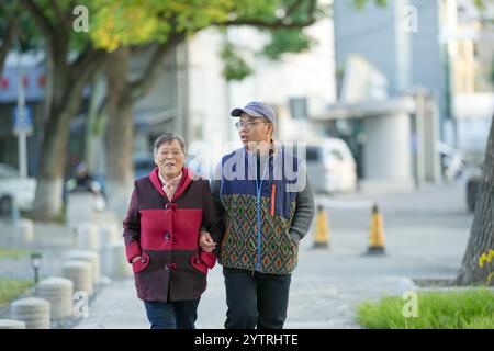 Chinesin in ihren 70ern und ihr Enkel, Mann in seinen 30ern, spazieren im Qingpu-Viertel von Shanghai, China, während der kalten Wintersaison entlang des Flusses. Stockfoto