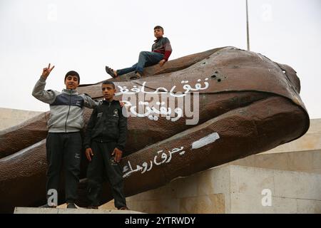 7. Dezember 2024: Hama, Syrien. Dezember 2024. Die abgerissene Statue des ehemaligen syrischen Präsidenten Hafez al-Assad in der syrischen Stadt Hama nach dem Vormarsch syrischer Rebellengruppen unter der Führung von Hayat Tahrir al-Sham. Eine große Anzahl von Kindern posierte in der Nähe der Statue, während sich die Ereignisse schnell entfalten, während der rasche Vormarsch der Opposition in Syrien, der am 27. November begann (Foto: © Juma Mohammad/IMAGESLIVE via ZUMA Press Wire) NUR REDAKTIONELLE VERWENDUNG! Nicht für kommerzielle ZWECKE! Stockfoto