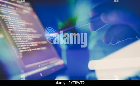 Hand mit Stylus, die mit Code auf einem Laptop-Bildschirm interagiert und Software-Entwicklung, Programmierung, Stockfoto