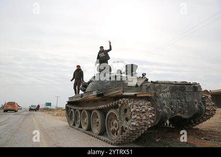 Hama, Syrien. Dezember 2024. Syrische Kinder inmitten von Militärfahrzeugen, die von syrischen Regierungstruppen verlassen wurden, als syrische Oppositionstruppen in die Stadt Hama eindringen. Seit dem 27. November sind syrische Oppositionsgruppen unter der Führung von Hayat Tahrir al-Sham stetig aus ihrer Festung in Idlib heraufgewachsen und haben große strategische Gebiete von der syrischen Regierung von Bashar Al-Assad eingenommen. Credit: IMAGESLIVE/Alamy Live News Stockfoto