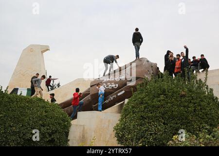 7. Dezember 2024: Hama, Syrien. Dezember 2024. Die abgerissene Statue des ehemaligen syrischen Präsidenten Hafez al-Assad in der syrischen Stadt Hama nach dem Vormarsch syrischer Rebellengruppen unter der Führung von Hayat Tahrir al-Sham. Eine große Anzahl von Kindern posierte in der Nähe der Statue, während sich die Ereignisse schnell entfalten, während der rasche Vormarsch der Opposition in Syrien, der am 27. November begann (Foto: © Juma Mohammad/IMAGESLIVE via ZUMA Press Wire) NUR REDAKTIONELLE VERWENDUNG! Nicht für kommerzielle ZWECKE! Stockfoto