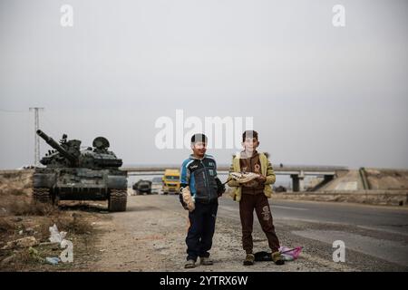 Hama, Syrien. Dezember 2024. Syrische Kinder inmitten von Militärfahrzeugen, die von syrischen Regierungstruppen verlassen wurden, als syrische Oppositionstruppen in die Stadt Hama eindringen. Seit dem 27. November sind syrische Oppositionsgruppen unter der Führung von Hayat Tahrir al-Sham stetig aus ihrer Festung in Idlib heraufgewachsen und haben große strategische Gebiete von der syrischen Regierung von Bashar Al-Assad eingenommen. Credit: IMAGESLIVE/Alamy Live News Stockfoto