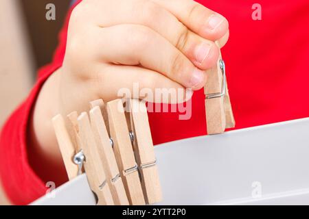 Vorschulkinder spielen mit Holzclip. Entwicklung von motorischen Fähigkeiten, Koordination, Kreativität und logischem Denken der Kinder Stockfoto