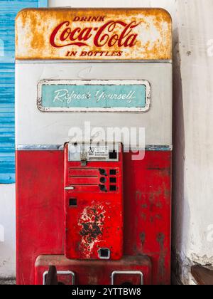 Vintage Coca-Cola-Maschine mit griechischem Inselgemälde Stockfoto