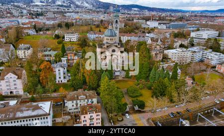 Atemberaubende Aussicht auf die historische Kirche, umgeben von üppigem Grün und charmanter Architektur in Zürich, Schweiz. Perfekter Schnappschuss Schweizer Tradition Stockfoto