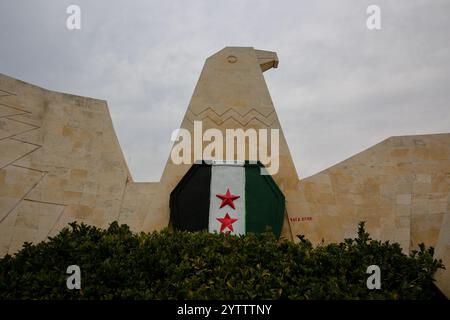 7. Dezember 2024: Hama, Syrien. Dezember 2024. Die syrische Oppositionsflagge ist auf einer adlerförmigen Mauer in Hama gemalt, nachdem Oppositionskämpfer die Stadt von den syrischen Regierungstruppen eingenommen haben. Seit dem 27. November sind syrische Oppositionsfraktionen unter der Führung von Hayat Tahrir al-Sham rasch aus ihrer Festung in Idlib vorgezogen und haben große strategische Gebiete von der syrischen Regierung von Baschar Al-Assad eingenommen. Die Rebellen haben ihre andauernde Militäroperation als „Abschreckung der Aggression“ bezeichnet (Credit Image: © Juma Mohammad/IMAGESLIVE via ZUMA Press Wire). Nicht für kommerzielle ZWECKE Stockfoto