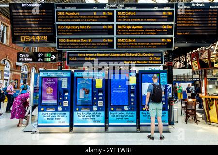 Mann, der Zugfahrkarten an Fahrkartenautomaten in der Halle des Bahnhofs Marylebone in London, England kauft Stockfoto