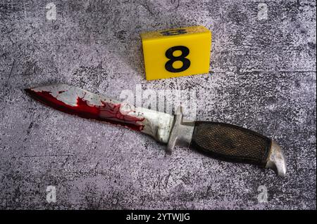 Und ein Kampfmesser, bedeckt mit einem blutigen Wald auf der Marmoroberfläche. Neben Gelb. Hochwertige Fotos Stockfoto