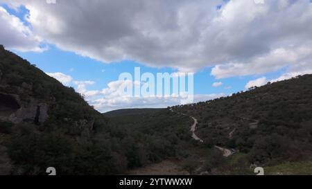 Buracas do Casmilo in Condeixa - Portugal. Alte Kalksteinhöhlen in einem zerklüfteten Hügel mit mehreren natürlichen Höhlenöffnungen im Grün Stockfoto