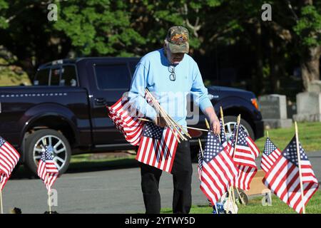 Woodbrook Cemetery, Woburn, MA. Mai 2023. Vietnam-Krieg und Purple Heart Veteran, der eine amerikanische Flagge auf das Grab eines Militärveteranen für Mem setzt Stockfoto