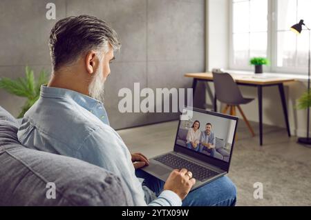 Seitenansicht eines Geschäftsmannes, der Videoanrufe mit seinen Freunden macht Stockfoto