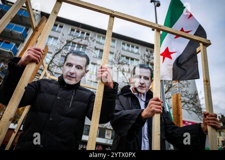 08. Dezember 2024, Nordrhein-Westfalen, Wuppertal: 2 Männer mit der Maske des syrischen Diktators Assad in einem symbolischen Gefängnis. Foto: Christoph Reichwein/dpa Stockfoto