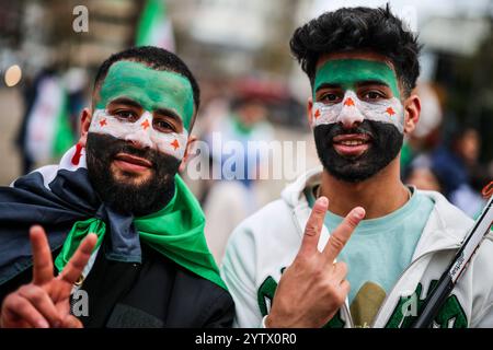 08. Dezember 2024, Nordrhein-Westfalen, Wuppertal: Zwei junge Männer malten sich für eine Kundgebung in Wuppertal eine syrische Flagge ins Gesicht. Foto: Christoph Reichwein/dpa Stockfoto