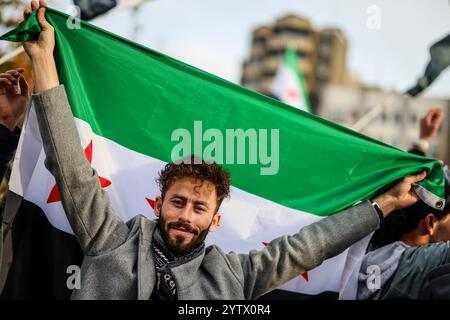 08. Dezember 2024, Nordrhein-Westfalen, Wuppertal: Ein Mann mit syrischer Flagge bei einer Kundgebung in Wuppertal. Foto: Christoph Reichwein/dpa Stockfoto